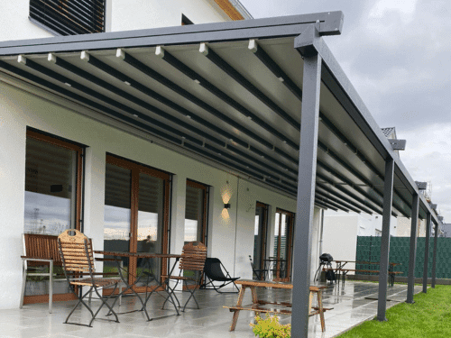 Pergola an einer Hauswand mit in die Träger integrierten Beleuchtungspunkten