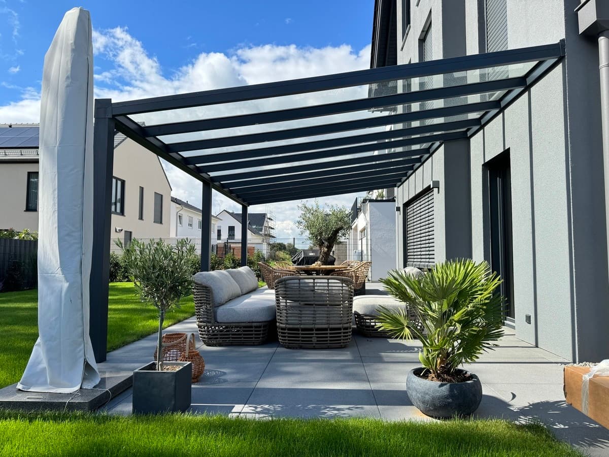 Terrassenüberdachung aus Aluminium mit Glaseindeckung an einem Wohnhaus